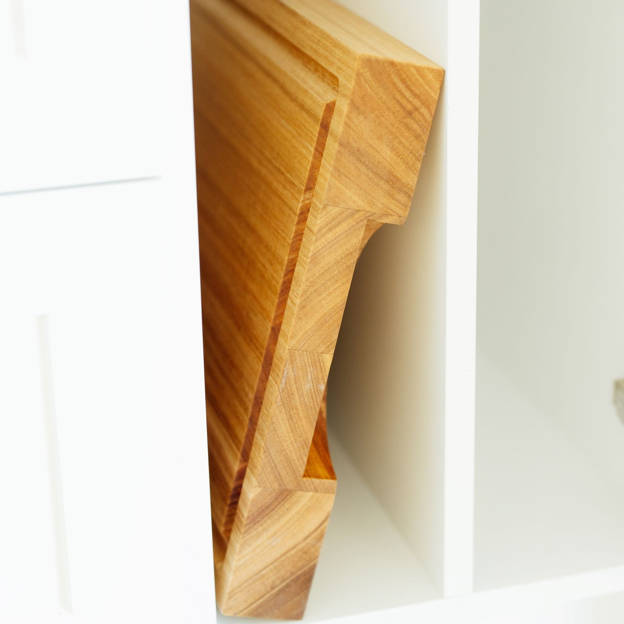 Wooden cutting board leaning against a white wall